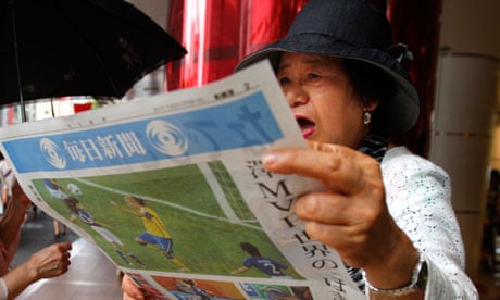 A woman reacts as she reads reports of the women's World Cup victory