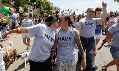 Two women, both active duty sailors in the Navy, kiss during the Gay Pride Parade in San Diego