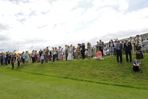 Glorious Goodwood Wed: Racegoers watch from a grassy bank near the finish line