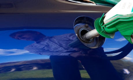 A motorist uses a petrol pump at a petrol station