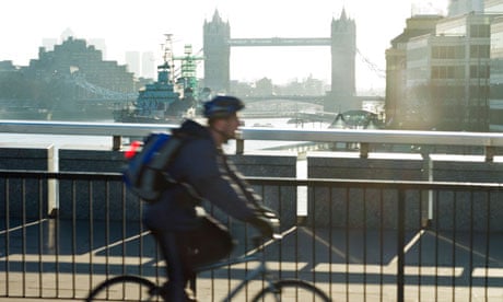 A man cycling to work over London Bridge