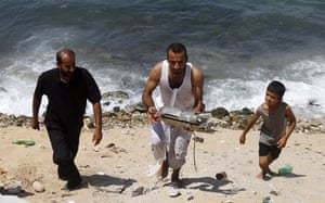 Israeli air strikes: A Palestinian man retrieves remains of a munition