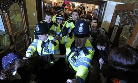 Police officers try to stop protesters occupying Fortnum & Mason