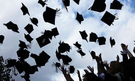 Students throw their mortarboards in the air after graduating