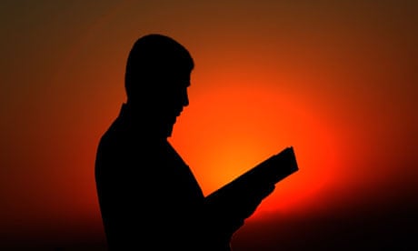 A Muslim man reads from the Qur'an in early morning prayers during Ramadan