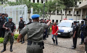 UN Abuja bomb blast: A U.N. staff member directs an ambulance after the bomb blast