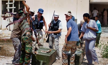 Libyan rebel fighters loot weapons from a military compound in Tripoli