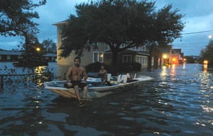 Hurricane Irene: Two men use a boat to explore a street flooded in Manteo, North Carolina