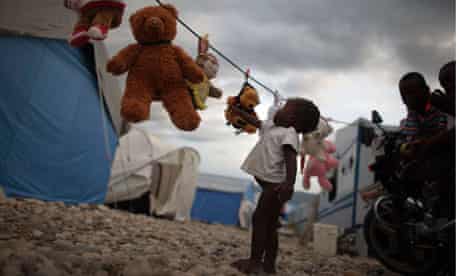 A homeless Haitian child reaches out for a stuffed animal