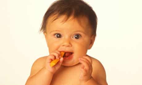 A baby eating a carrot