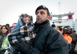 Cruise Aground: A police officer holds a baby from the luxury ship Costa Concordia