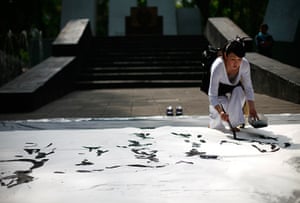 24 hours in pictures: Japanese artist and calligrapher paints in a park in Mexico City