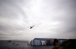 costa concordia: A rescue helicopter flies over the Costa Concordia cruiseship 