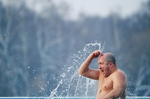 Orthodox Epiphany:  man crosses himself as he emerges from the water of a lake in Moscow