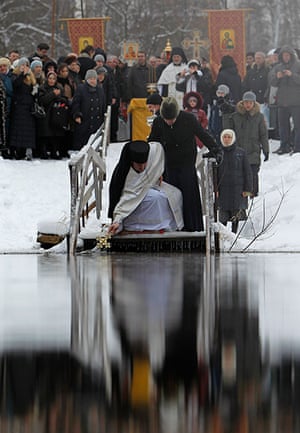 Orthodox Epiphany: An Orthodox priest dips a cross in the water of the Istra river