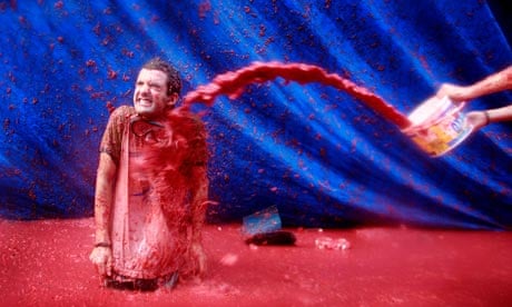 A reveller is hit by a bucket of tomato pulp during the annual Tomatina food fight