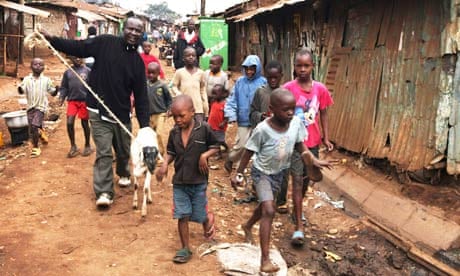 Children walk beside a man leading his sheep in the sprawling Kibera slum near Nairobi