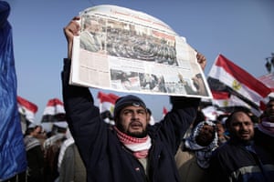 Egypt rally: An Egyptian man holds a newspaper showing the opening session of parliament