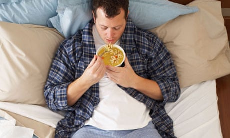 Man sick in bed eating soup