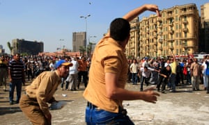 A protester throws a stone after scuffles broke out between groups of several hundred protesters in Tahrir Square when chants against the new Islamist president angered some in the crowd in Cairo, today. Photograph: AP/Khalil Hamra