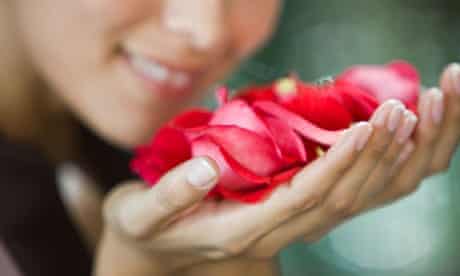 A woman smelling rose flowers