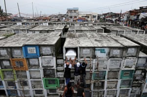 24 hours: Manila, Philippines: Workers place the coffin in a grave at the cemetery