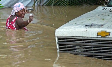 A resident of Leogane, Haiti makes her way to her home as the water level continues to rise on 26 October 2012. Photograph: Carl Juste/AP