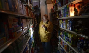 A man shops for groceries by flashlight at an East Village grocery store in New York as New Yorkers cope with the aftermath of Hurricane Sandy. The storm left large parts of New York without power and transportation.