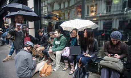 New Yorkers from mid and downtown who are without electricity in their homes, gather to charge their phones and laptops from the sidewalk electrical outlets and power sources belonging to local hotels.