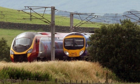 A Virgin train passing a First Group train on the west coast mainline. Photograph: David Cheskin/PA