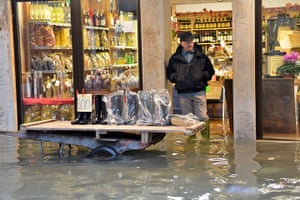 Venice floods: A shoe seller displays wellies outside his shop 