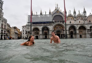 Venice floods: A young man and a woman swim in flooded St Mark's Square