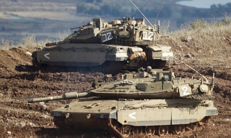 Israeli tanks, one in position, the other getting into a firing position in the Israeli-controlled Golan Heights overlooking the Syrian village of Bariqa on  Monday. The Israeli military says "Syrian mobile artillery" was hit after responding to stray mortar fire from its northern neighbour.