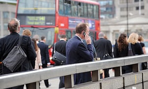 Commuters walking over London Bridge on way to work in the City of London