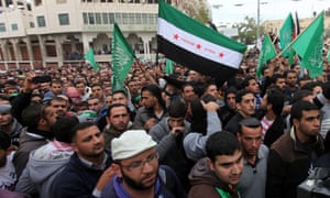 Palestinian supporters of the Islamist movement Hamas wave their flag as well as a pre-Ba'ath Syrian flag during a demonstration in the West Bank city of Hebron on 21 November  2012 to show solidarity with Palestinians in the Gaza Strip.
