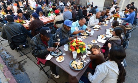 A child rests her head on the table as some homeless people have their lunch at the LA Mission's annual Thanksgiving meal.