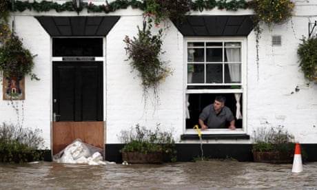 David Boazman, landlord of the White Bear Pub in Tewkesbury looks out of the window at the flood water as he tried to pump some water from the building.