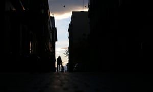 A woman walks with her bicycle in central Madrid.