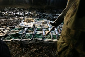 Mexico drug wars gallery: A soldier stands near guns and ammunition 