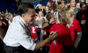 Mitt Romney signs an autograph for a young supporter during a rally in Des Moines, Iowa