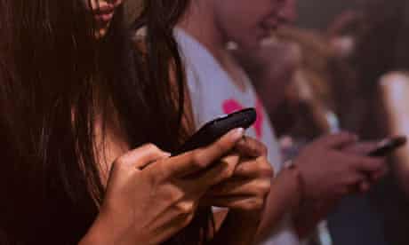 Young woman and man texting in nightclub
