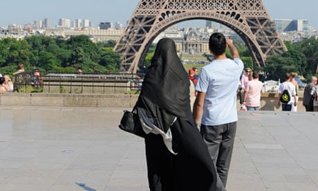 A woman wearing niqab walks at Square Trocadero near the Eiffel Tower in Paris