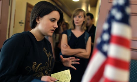 College student Paige McLoughlin, 19, of Parker, Colorado, talks over paperwork with an electoral official before voting.