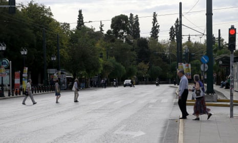Pedestrian cross the usually crowded Amalias street few hours before the planned protest in Athens on Wednesday Nov. 7, 2012.