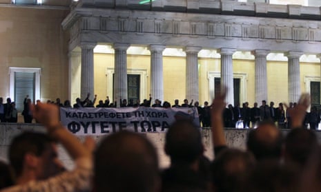 Parliamentary members of the Coalition of the Radical Left (SYRIZA) party hold a banner at the entrance of the Greek Parliament reading 'You destroy the country - Leave now' while waving to the people gathered outside the Parliament in Athens, Greece, 07 November 2012.