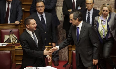 Greek Finance Minister Yannis Stournaras (L) shakes hands with Greek Prime Minister Antonis Samaras at the end of a session of the Greek parliament dedicated to new austerity measures, in Athens on November 7, 2012