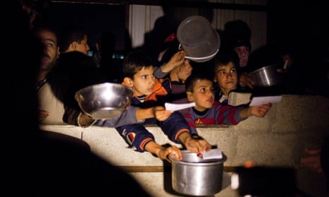 Displaced Syrians, children and adults, wait for the daily distribution of food provided by a Turkish NGO at the Syrian Internal Displaced Camp, 4 km outside the northern city of Azaz, on the border between Syria and Turkey.