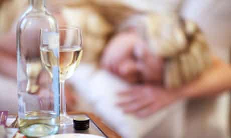 Bottle of wine and young woman asleep 
