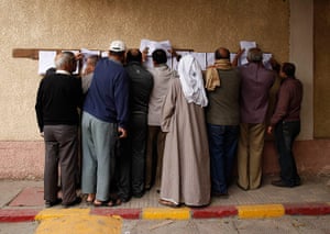 Egypt Referendum: People look for their names at a polling station before casting their votes