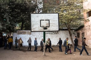 Egypt Referendum: Egyptian men walk through the basketball court of a school on their way to cast their votes